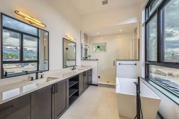 a bathroom with a double vanity sink mirror and shower