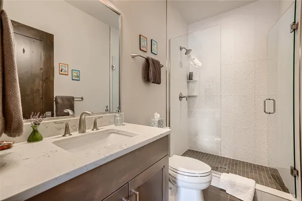 a bathroom with a sink a toilet and shower