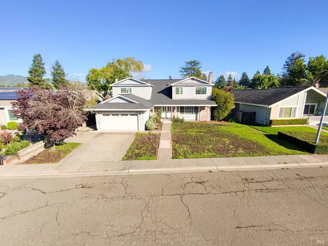 a front view of a house with a yard and a garage
