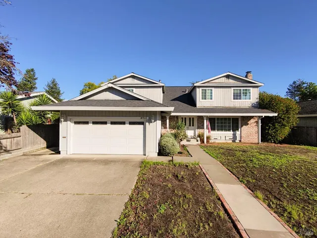 a front view of a house with a yard and potted plants