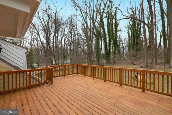 a view of deck with wooden floor and fence next to a yard