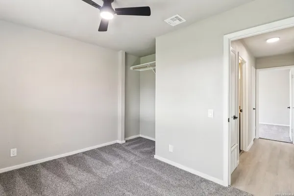 an empty room with closet and windows