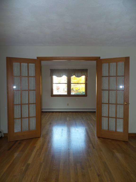 114 Avalon Road Reading, MA 01867 - Photo 3 of 29 an empty room with wooden floor cabinet and windows