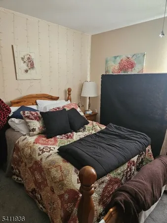 a bedroom with two bed and a painting on the wall