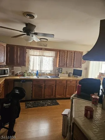 a kitchen with stainless steel appliances granite countertop a stove top oven a sink a dining table and chairs with white cabinets
