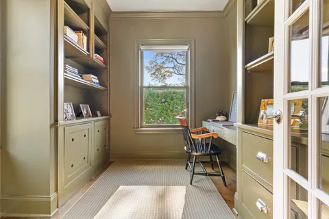 a view of a workspace with furniture and a window