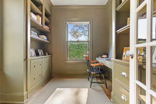 a view of a workspace with furniture and a window