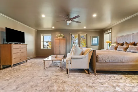 a spacious bedroom with a bed and a flat screen tv