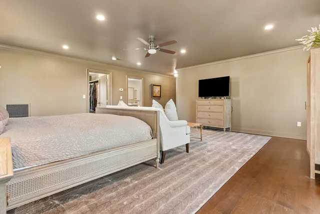 a bedroom with a large bed and a flat screen tv