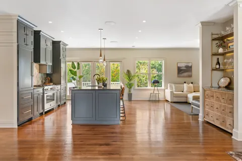 a living room with furniture large window and wooden floor
