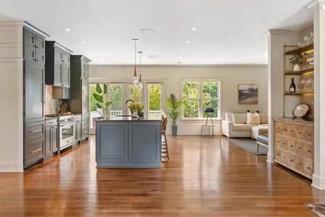 a living room with furniture large window and wooden floor