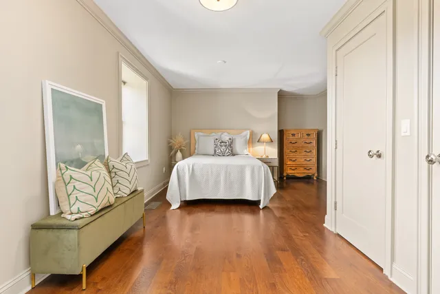 a spacious bedroom with a bed and wooden floor