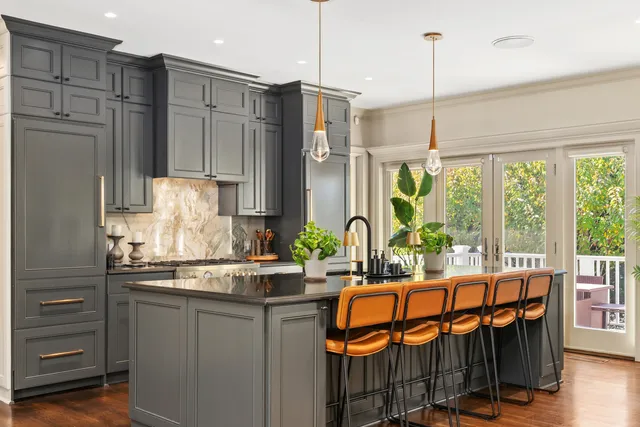 a kitchen with stainless steel appliances kitchen island granite countertop a refrigerator a stove and a wooden floors