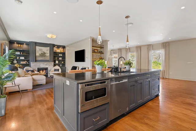 a kitchen with stainless steel appliances granite countertop a stove and a wooden floors