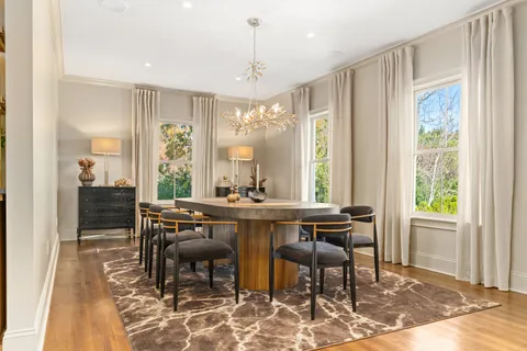 a view of a a dining room with furniture window and wooden floor