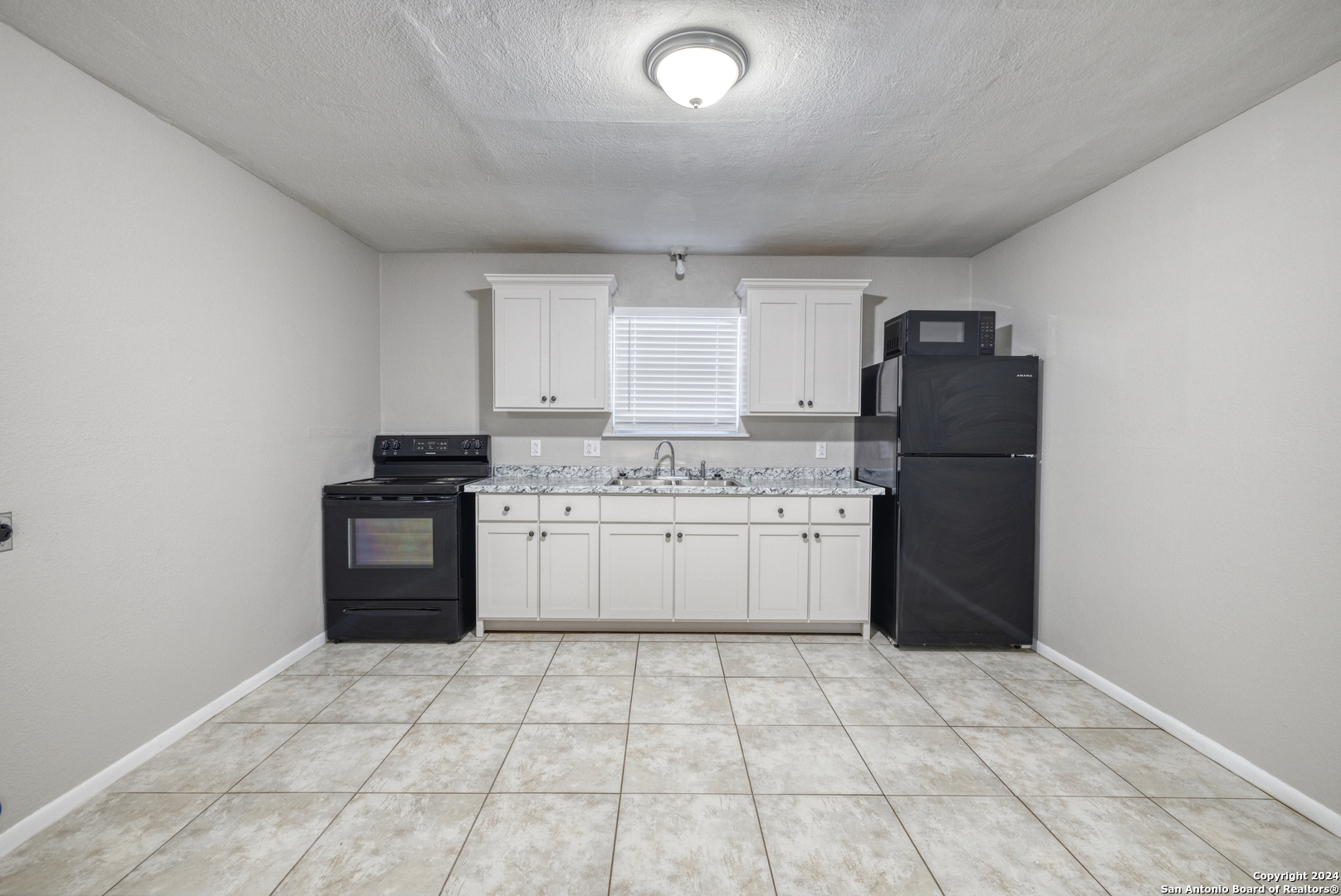 640 Roach Street Uvalde, TX 78801 - Photo 5 of 23 a kitchen with a stove a refrigerator and cabinets