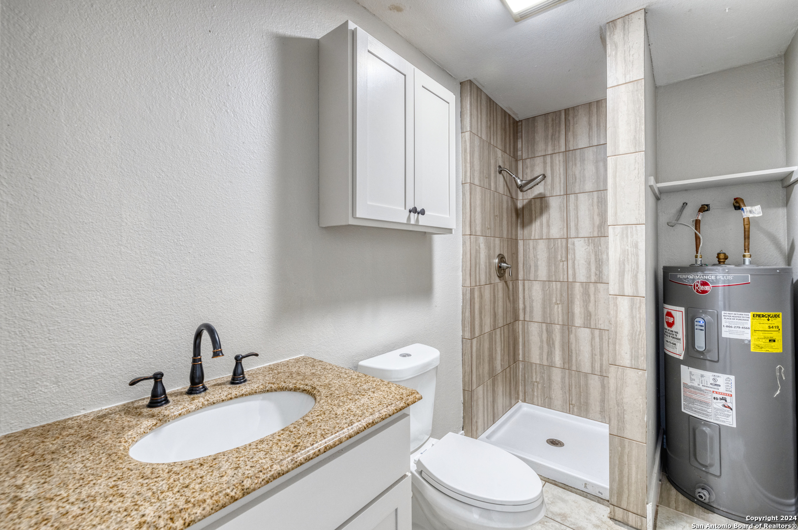 640 Roach Street Uvalde, TX 78801 - Photo 10 of 23 a bathroom with a granite countertop sink toilet and shower