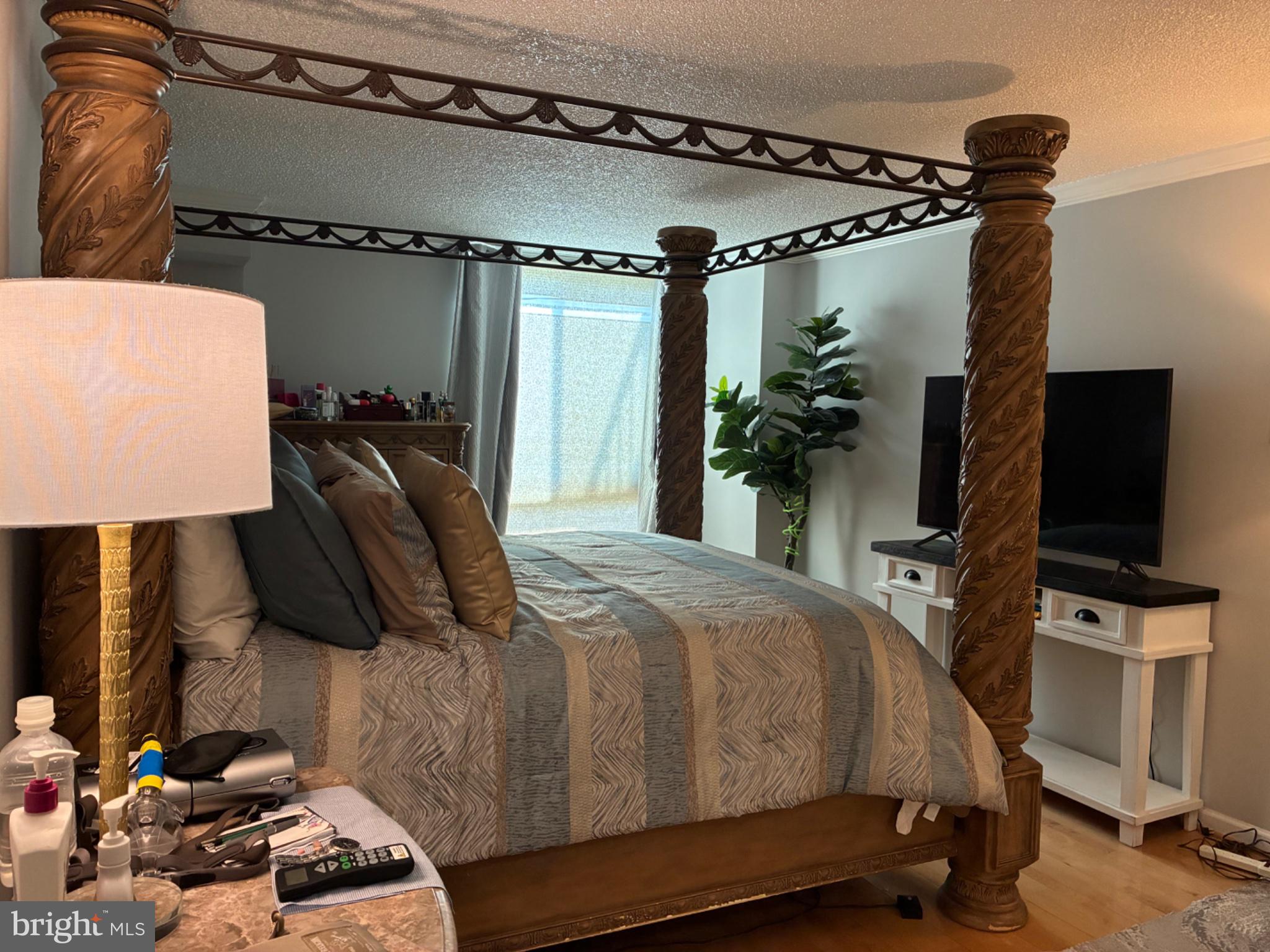 1800 Old Meadow Road, Unit 101 McLean, VA 22102 - Photo 45 of 50 a bedroom with a bed a flat screen tv and a mirror