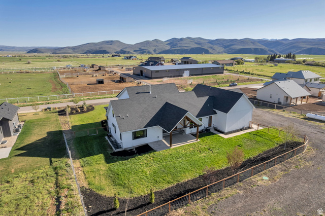 1820 West Farmhouse Flats Road Peoa, UT 84061 - Photo 79 of 79 Modern farmhouse architectural style featuring a white exterior, dark shingle roof, and a covered patio with exposed wood beams