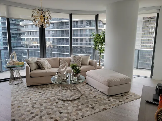 a living room with furniture and a chandelier