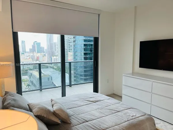 a bedroom with a bed and large window