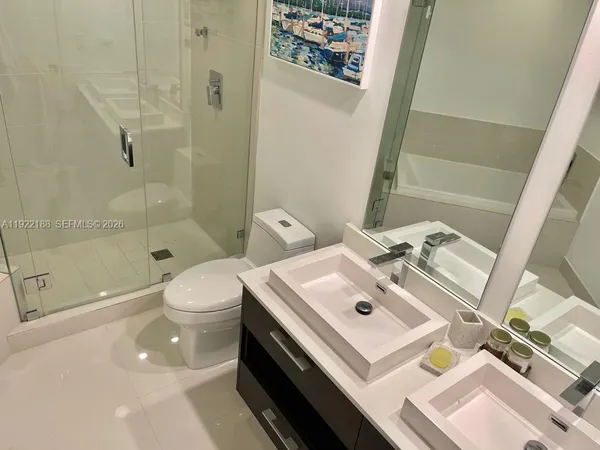 a bathroom with a sink a toilet and shower