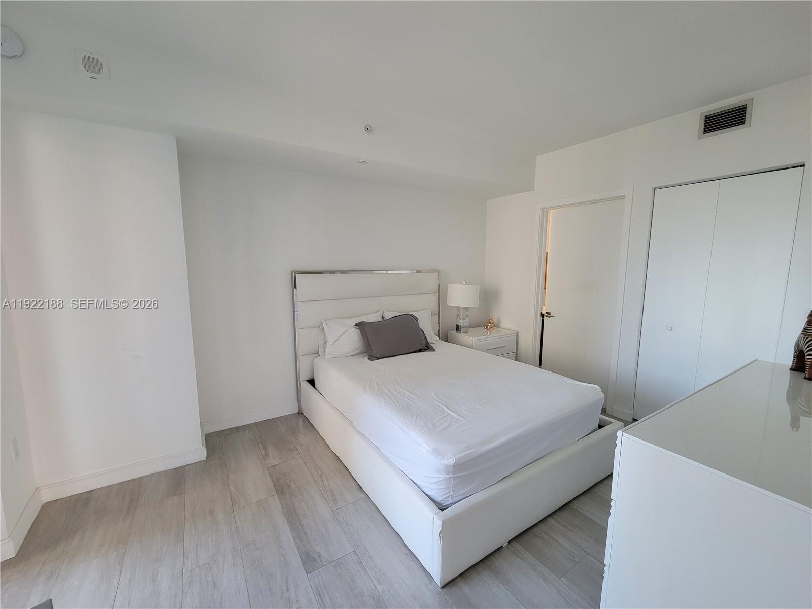 45 Southwest 9th Street, Unit 2201 Miami, FL 33130 - Photo 18 of 36 a bedroom with a bed and wooden floor