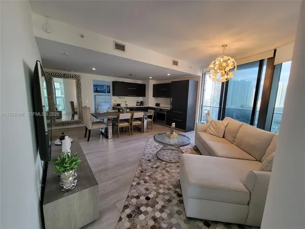 a living room with furniture and a chandelier
