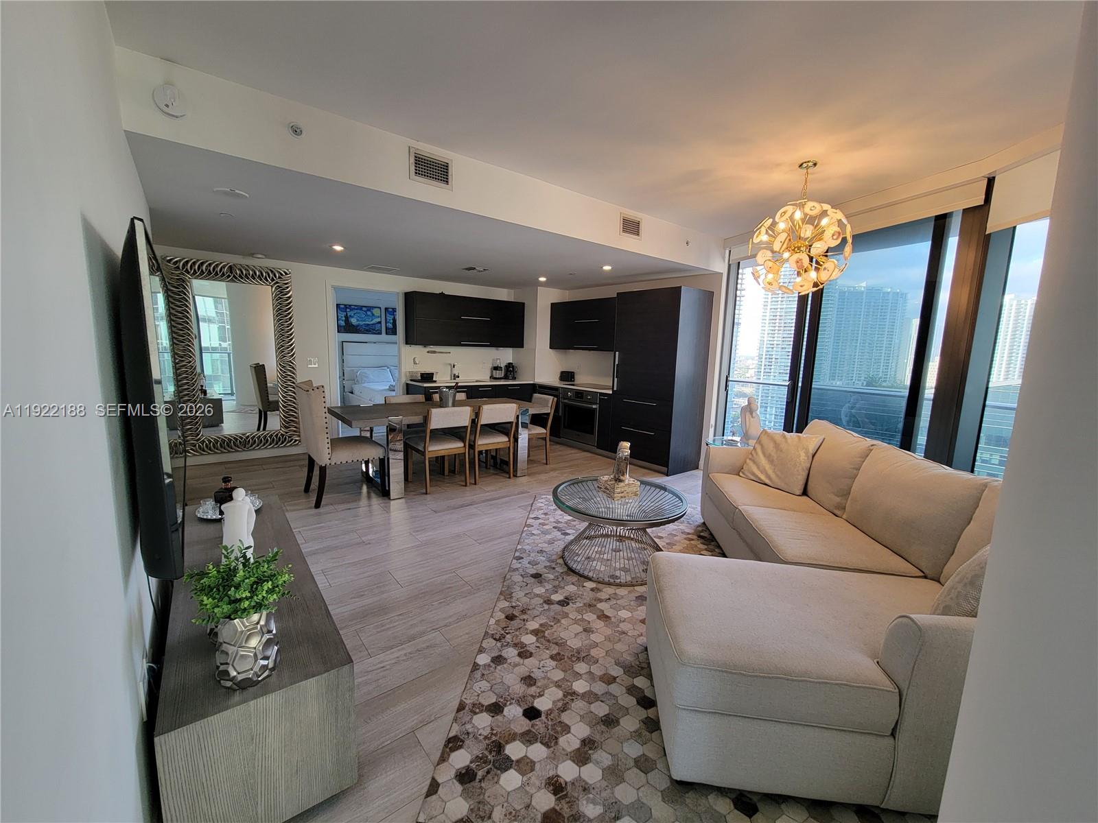 45 Southwest 9th Street, Unit 2201 Miami, FL 33130 - Photo 6 of 36 a living room with furniture and a chandelier