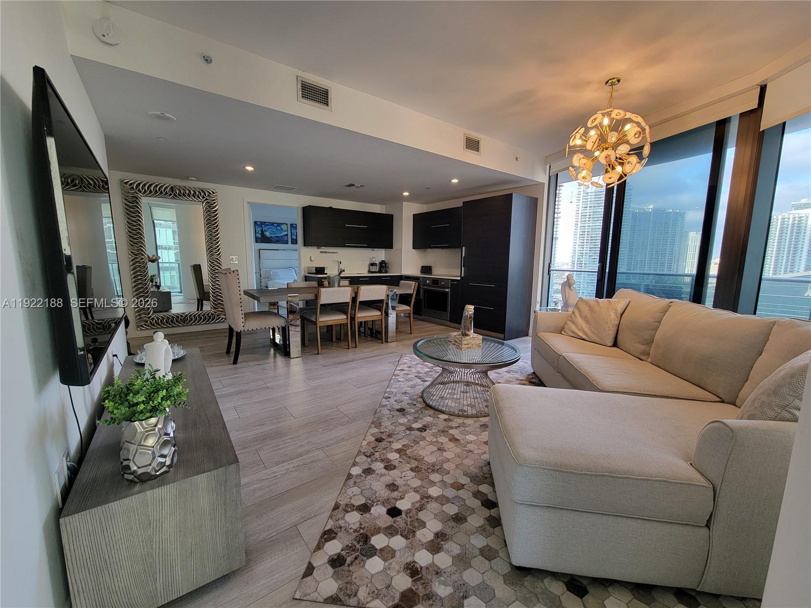 45 Southwest 9th Street, Unit 2201 Miami, FL 33130 - Photo 7 of 36 a living room with furniture and a chandelier