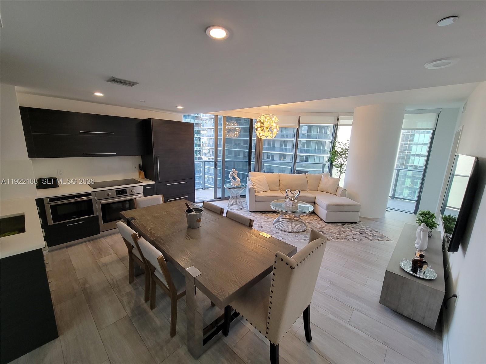 45 Southwest 9th Street, Unit 2201 Miami, FL 33130 - Photo 8 of 36 a living room with furniture and a flat screen tv