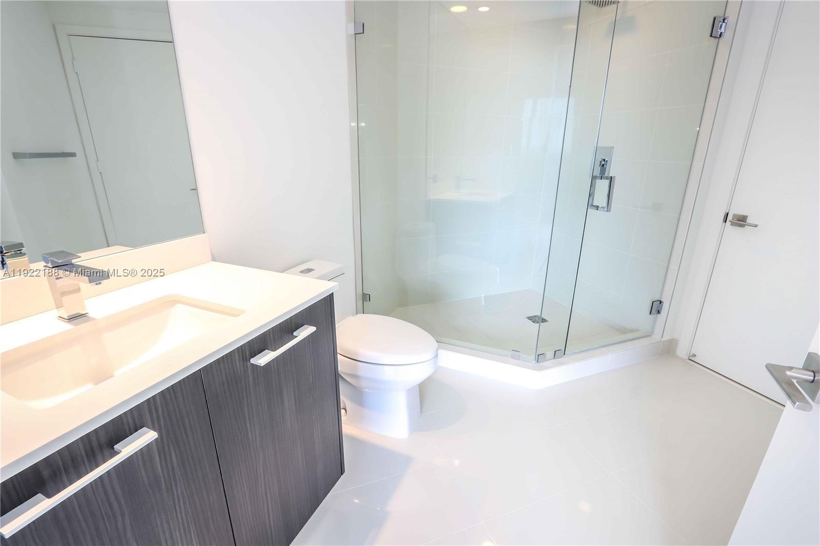 45 Southwest 9th Street, Unit 2201 Miami, FL 33130 - Photo 10 of 28 a bathroom with a sink a toilet and shower