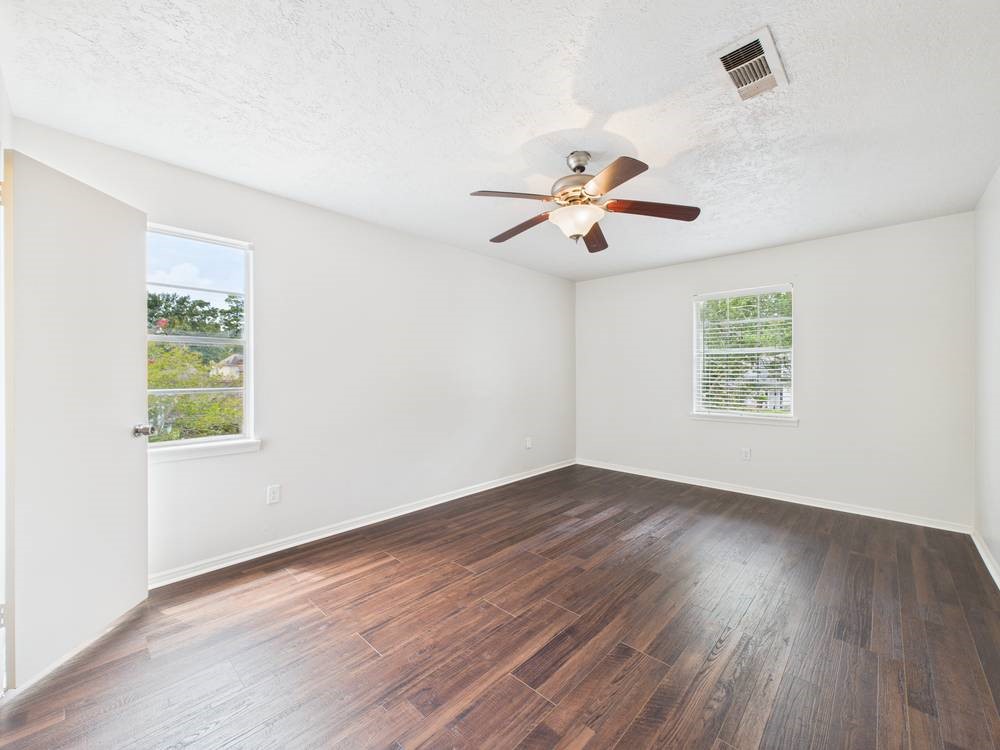 8315 Lichen Lane Spring, TX 77379 - Photo 20 of 31 an empty room with wooden floor and windows