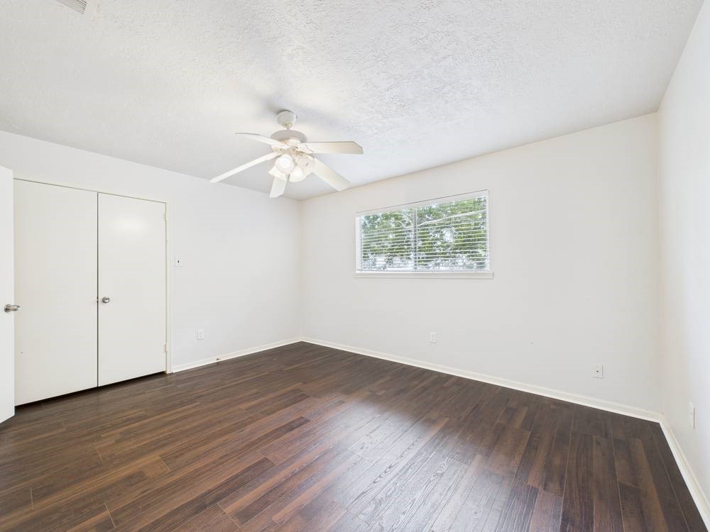 8315 Lichen Lane Spring, TX 77379 - Photo 22 of 31 an empty room with wooden floor chandelier fan and windows