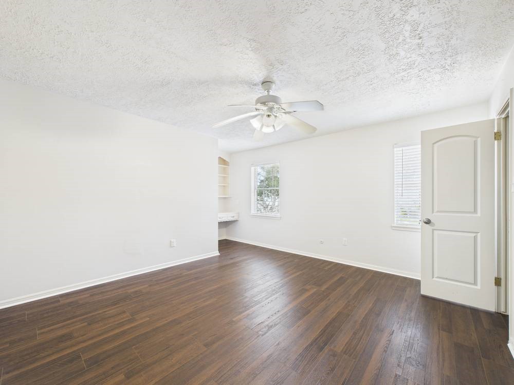 8315 Lichen Lane Spring, TX 77379 - Photo 25 of 31 an empty room with wooden floor and windows