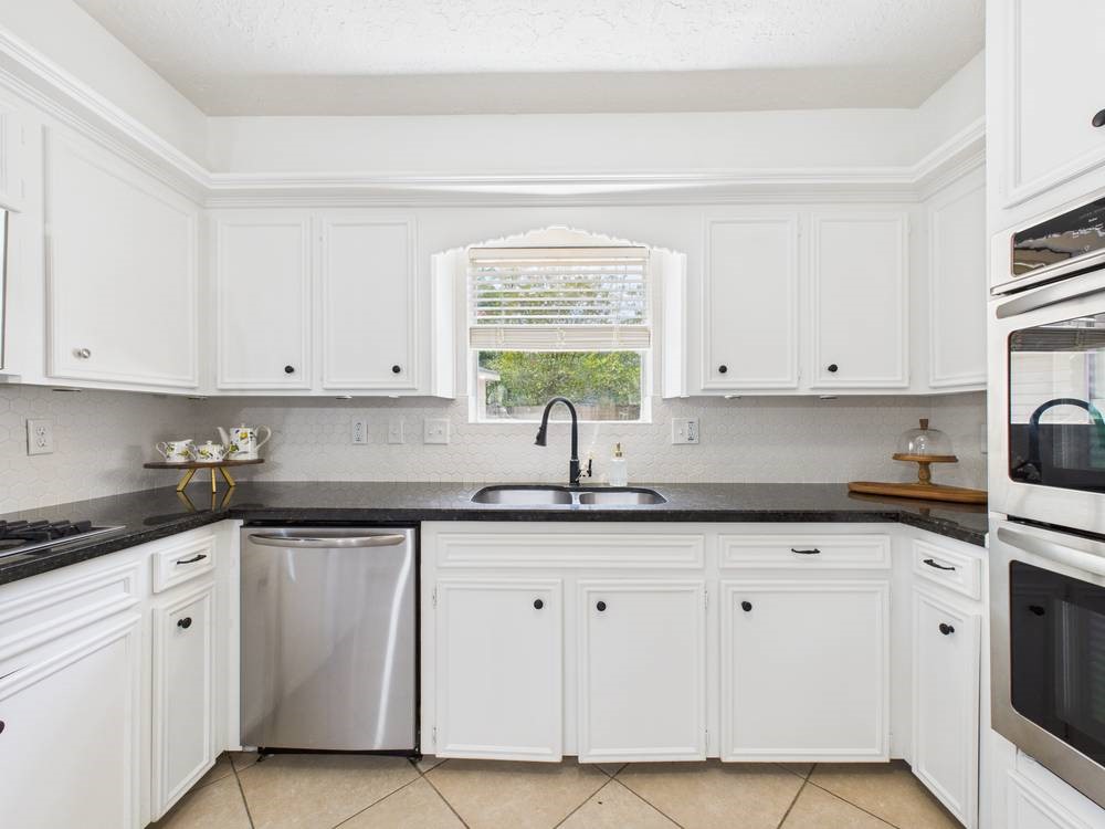 8315 Lichen Lane Spring, TX 77379 - Photo 10 of 31 a kitchen with white cabinets white appliances and a sink