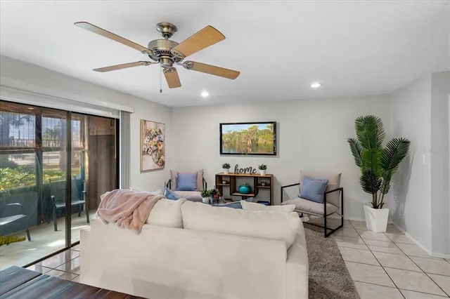 a living room with furniture a chandelier and a flat screen tv