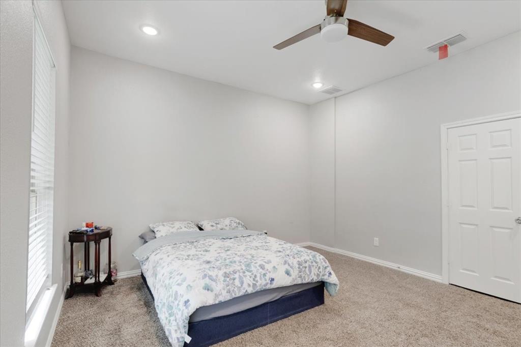 721 Maple Street Bonham, TX 75418 - Photo 13 of 30 a bedroom with a bed and a chandelier