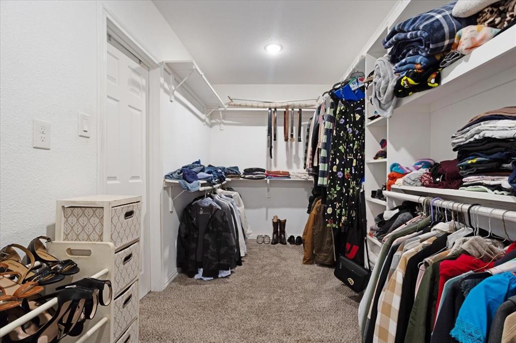 721 Maple Street Bonham, TX 75418 - Photo 16 of 30 a view of walk in closet with clothes and shoes