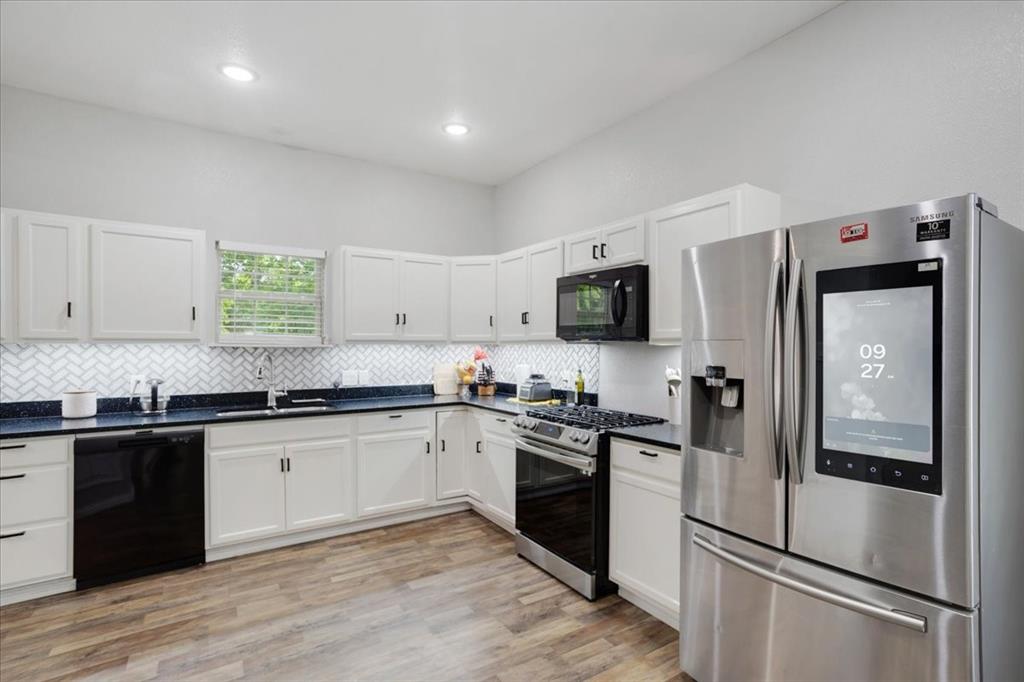 721 Maple Street Bonham, TX 75418 - Photo 7 of 30 a kitchen with granite countertop a refrigerator stove and sink