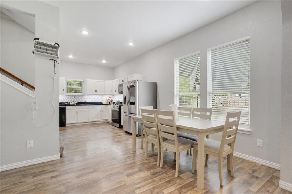 721 Maple Street Bonham, TX 75418 - Photo 8 of 30 a kitchen with a dining table chairs and white appliances