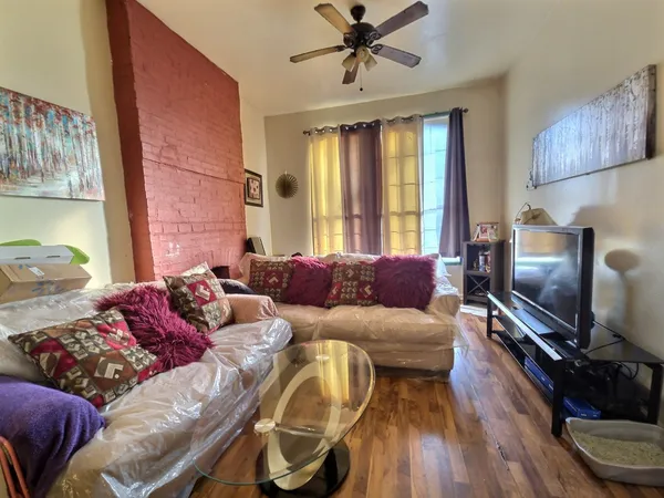 a living room with furniture a window and a flat screen tv