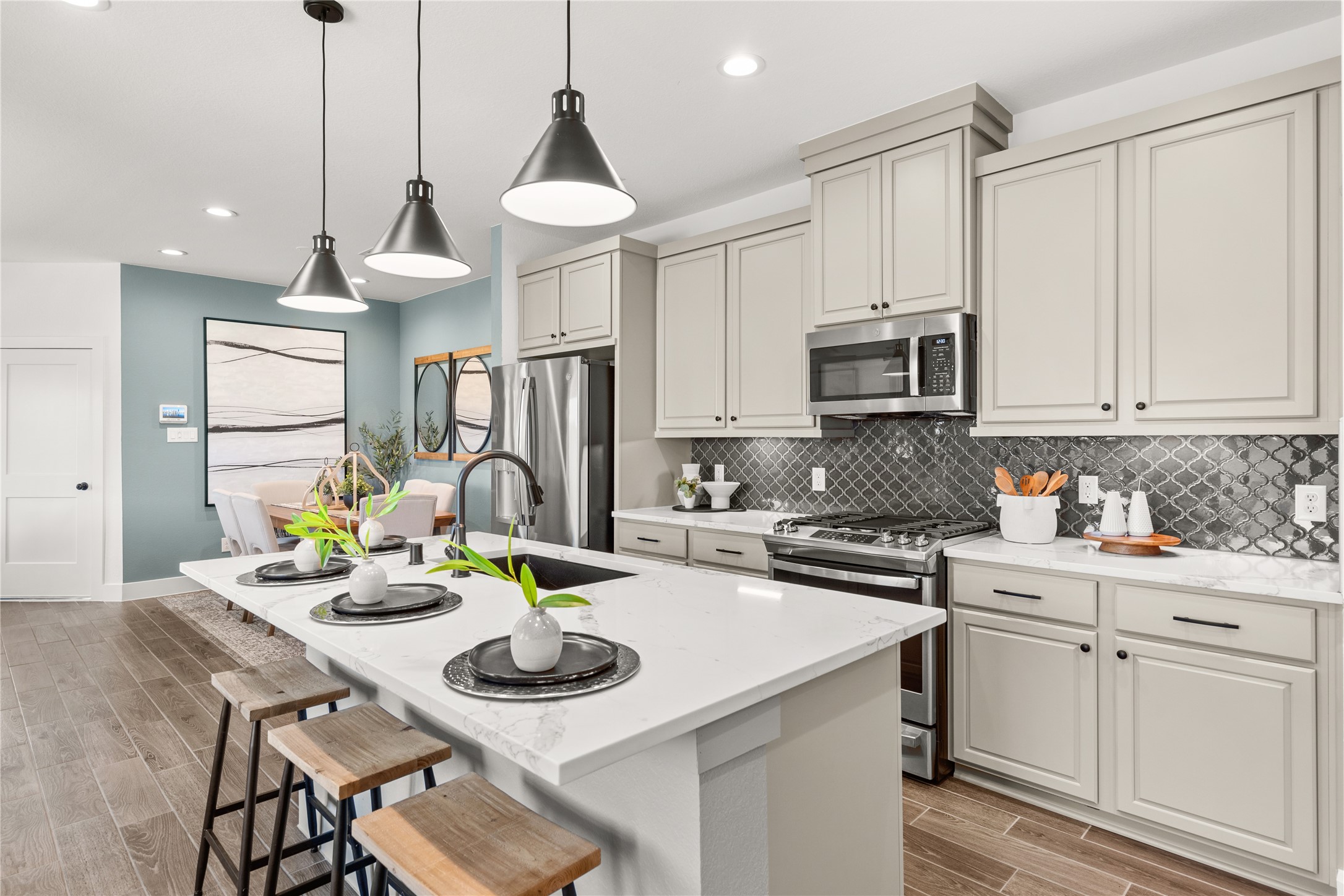 5255 Celestial Court Iowa Colony, TX 77583 - Photo 15 of 29 a kitchen with white cabinets a sink dining table and chairs