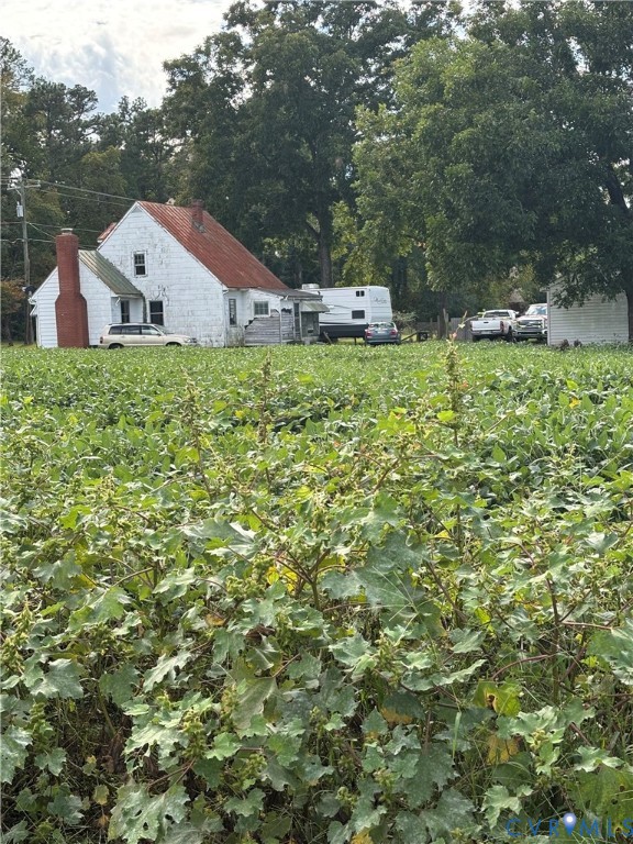 a white house with a big yard and large trees
