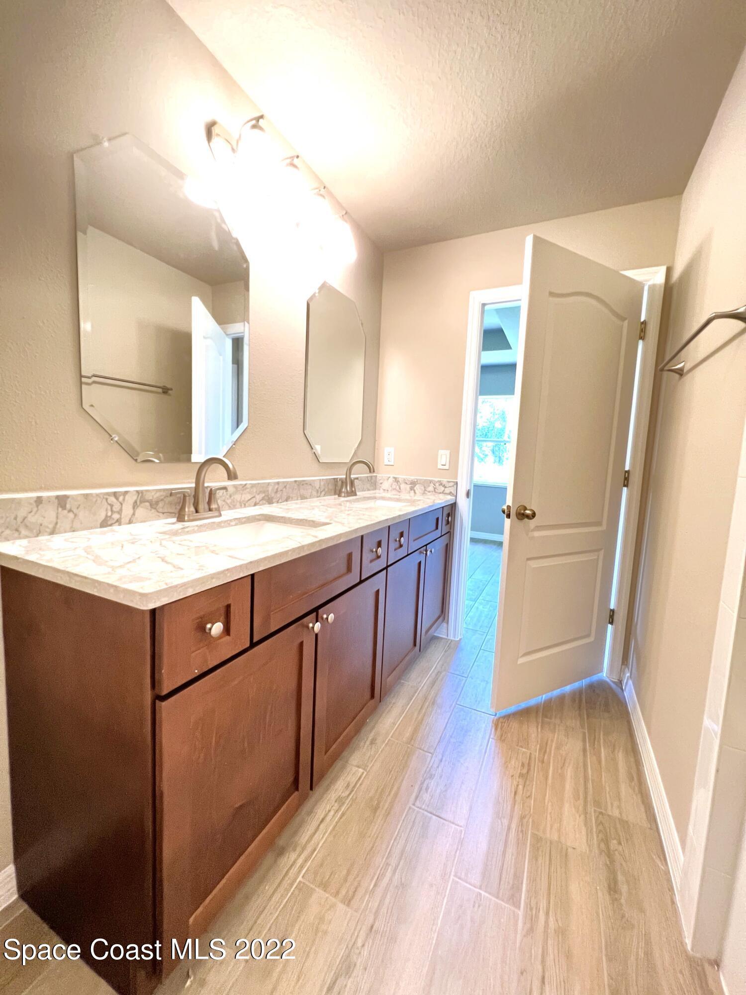 449 Alison Street Titusville, FL 32780 - Photo 12 of 18 a bathroom with a sink a mirror and a shower