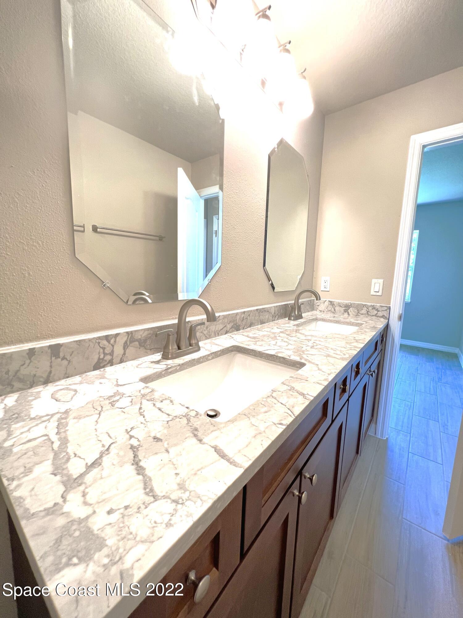 449 Alison Street Titusville, FL 32780 - Photo 13 of 18 a bathroom with a granite countertop sink and a mirror