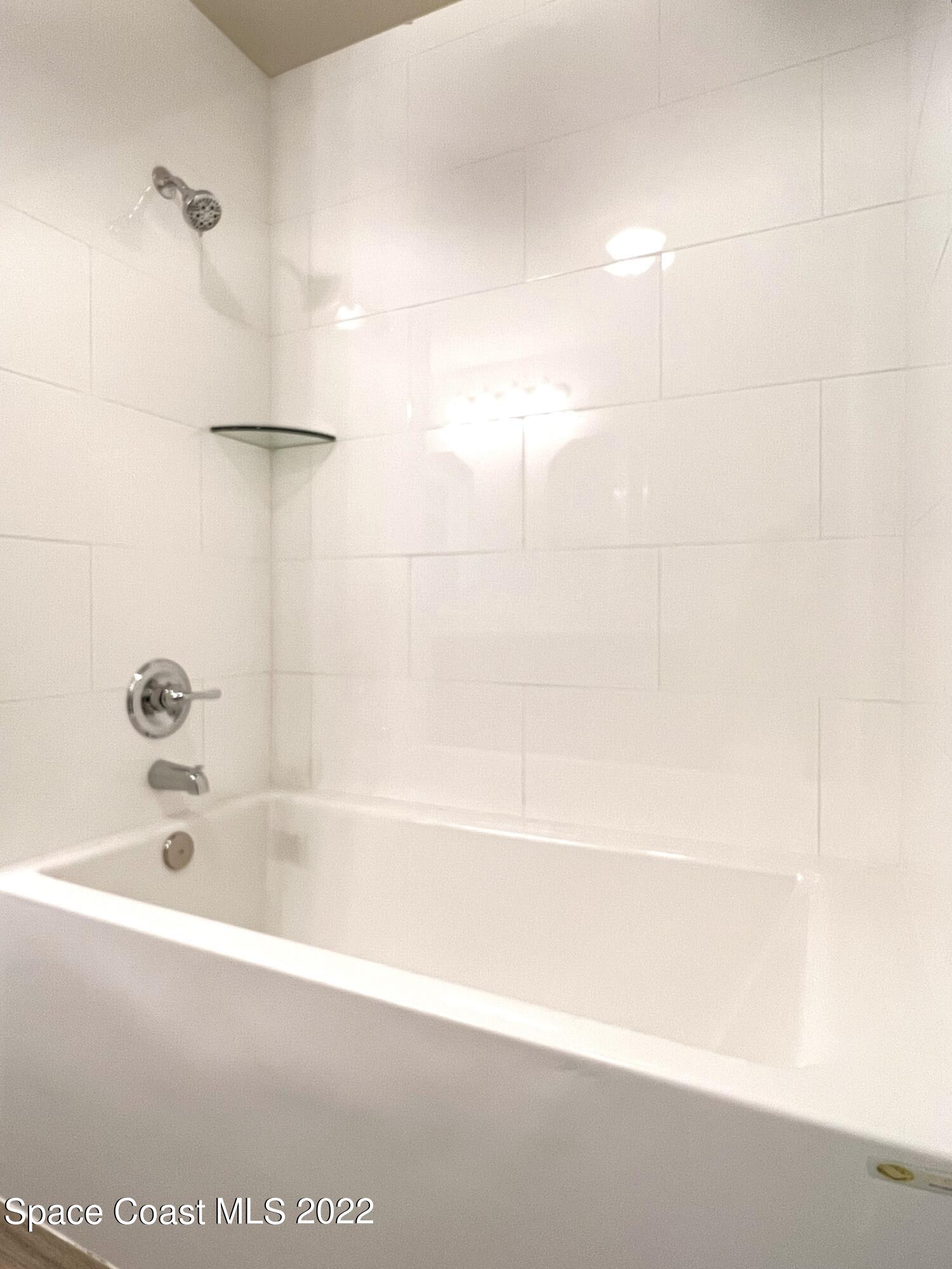 449 Alison Street Titusville, FL 32780 - Photo 14 of 18 a bathroom with a bathtub and a shower