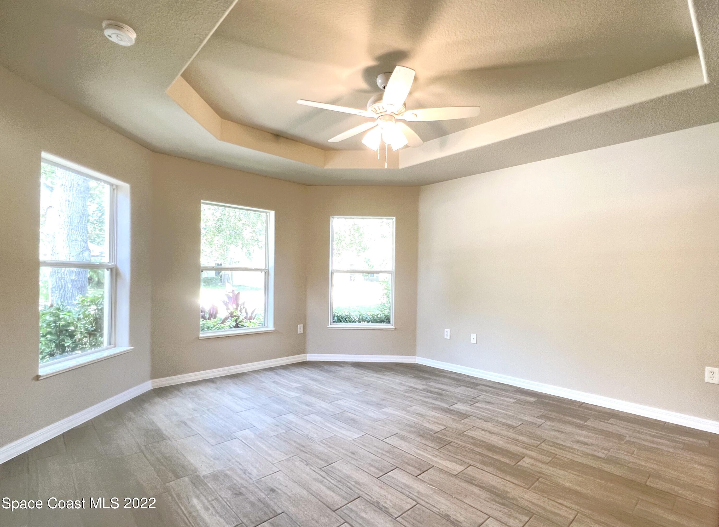 449 Alison Street Titusville, FL 32780 - Photo 3 of 18 a view of an empty room with wooden floor and window