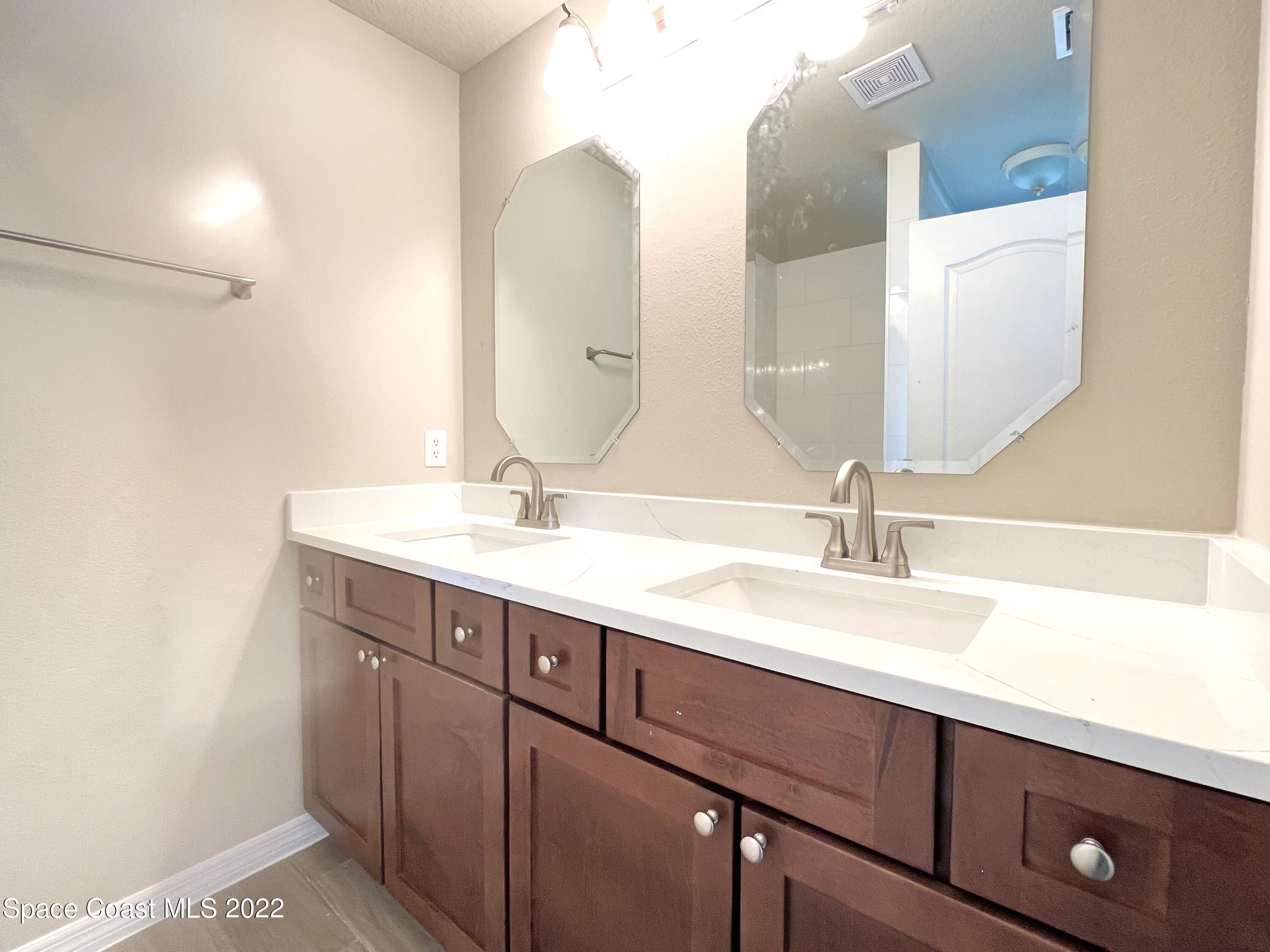 449 Alison Street Titusville, FL 32780 - Photo 4 of 18 a bathroom with a double vanity sink and a mirror