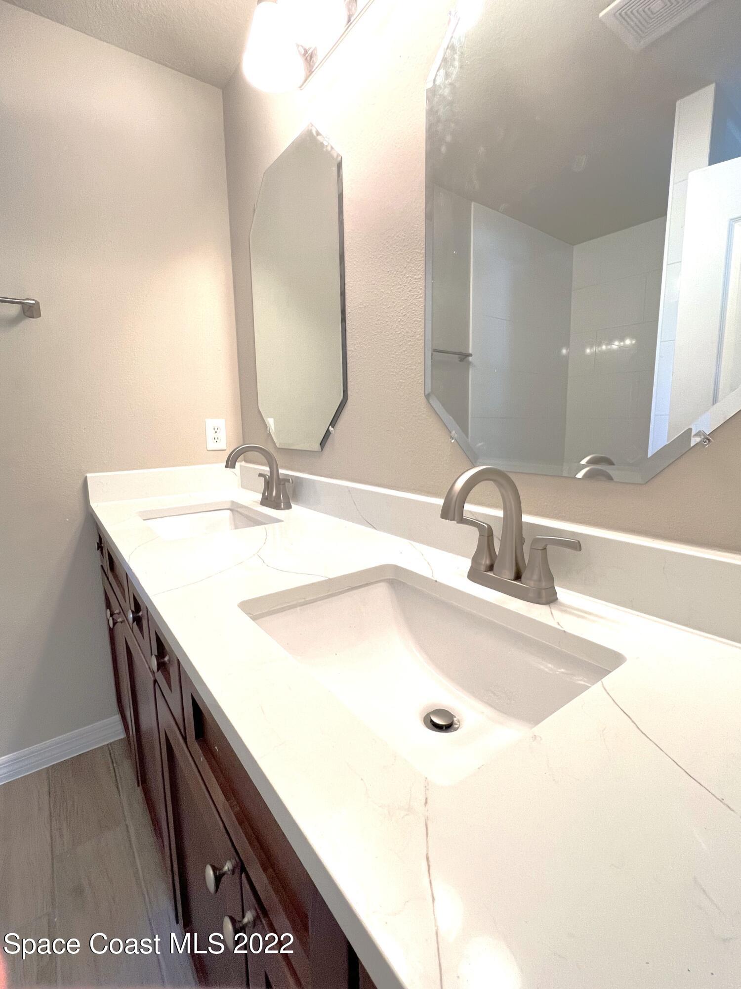 449 Alison Street Titusville, FL 32780 - Photo 5 of 18 a bathroom with a double vanity sink and a mirror